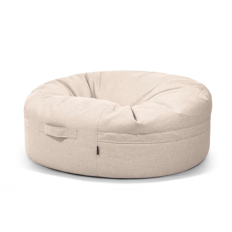 El Bean Bag Roll 135 Riviera - uso exteriores es un sillón redondo de color beige claro con asa lateral, ideal como puff o asiento informal, mostrado sobre fondo blanco.