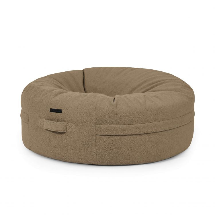 The Puff gigante redondo de tejido borreguito 135×135×50 cm ROLL 135 TEDDY, estilo moderno para salón, presenta un diseño beige suave y asa lateral, ideal para relajarse, expuesto sobre fondo blanco.