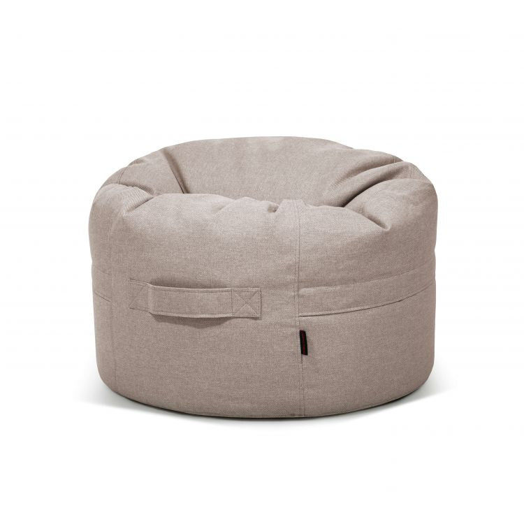 El Puff redondo de tejido antimanchas y repelente al agua 80×80×35 cm ROLL 80 RIVIERA, apto para interior y exterior, presenta asa lateral para fácil transporte y se muestra sobre fondo blanco.