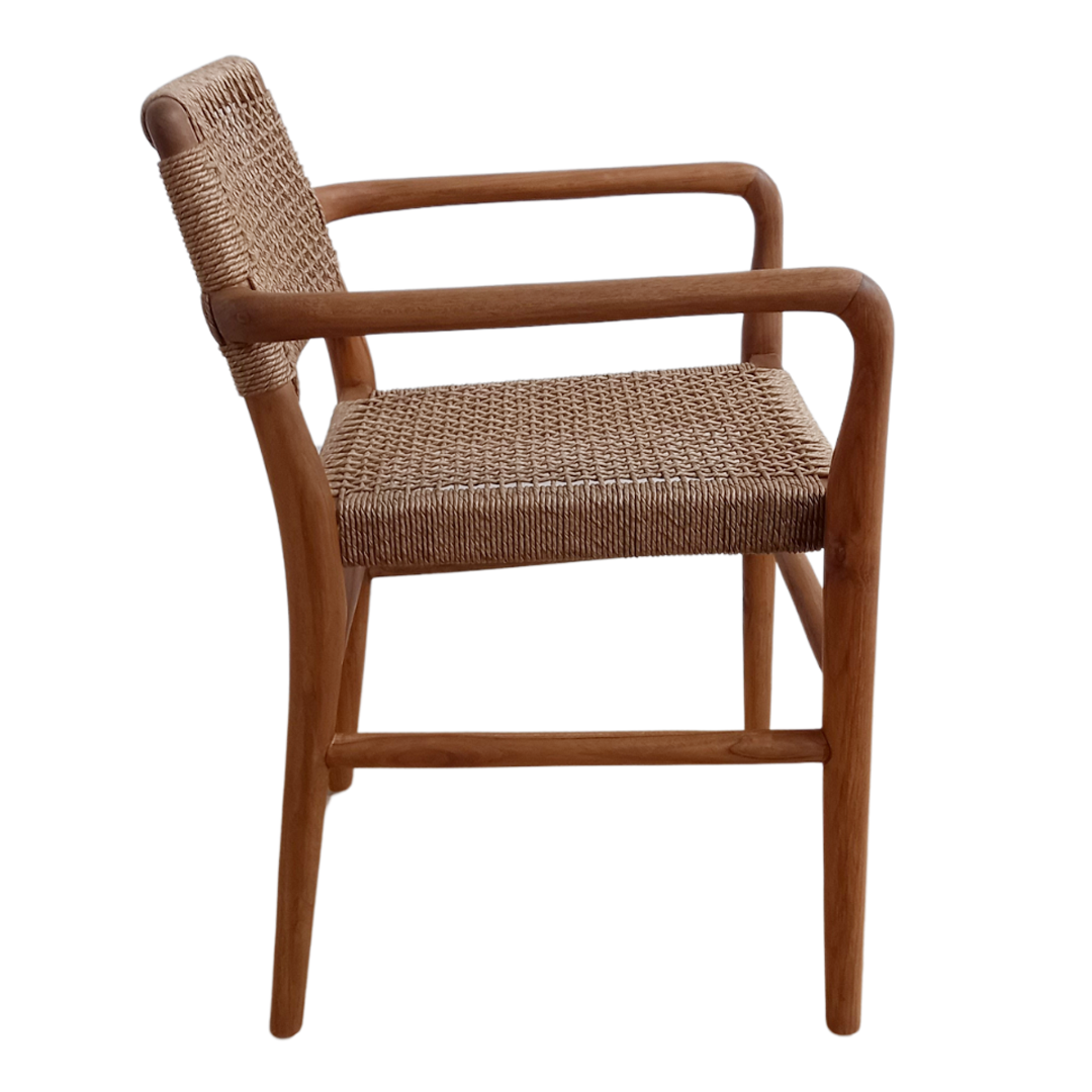 Vista lateral de la Silla de Comedor en Madera de Teca y Fibra sintética Nina, con estructura de madera de teca con asiento y respaldo de fibra sintética tejida, reposabrazos curvados y patas, mostrada aislada sobre fondo blanco.