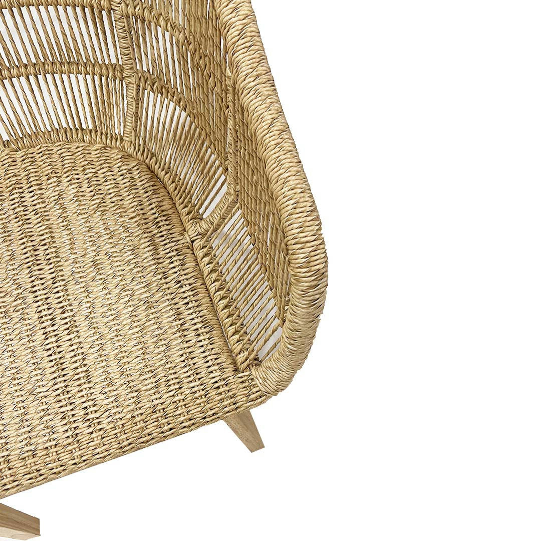 La Silla de comedor Ratán Teca Natural Corda cuenta con un respaldo alto, mostrando su diseño envolvente en ángulo y la textura intrincada del tejido.