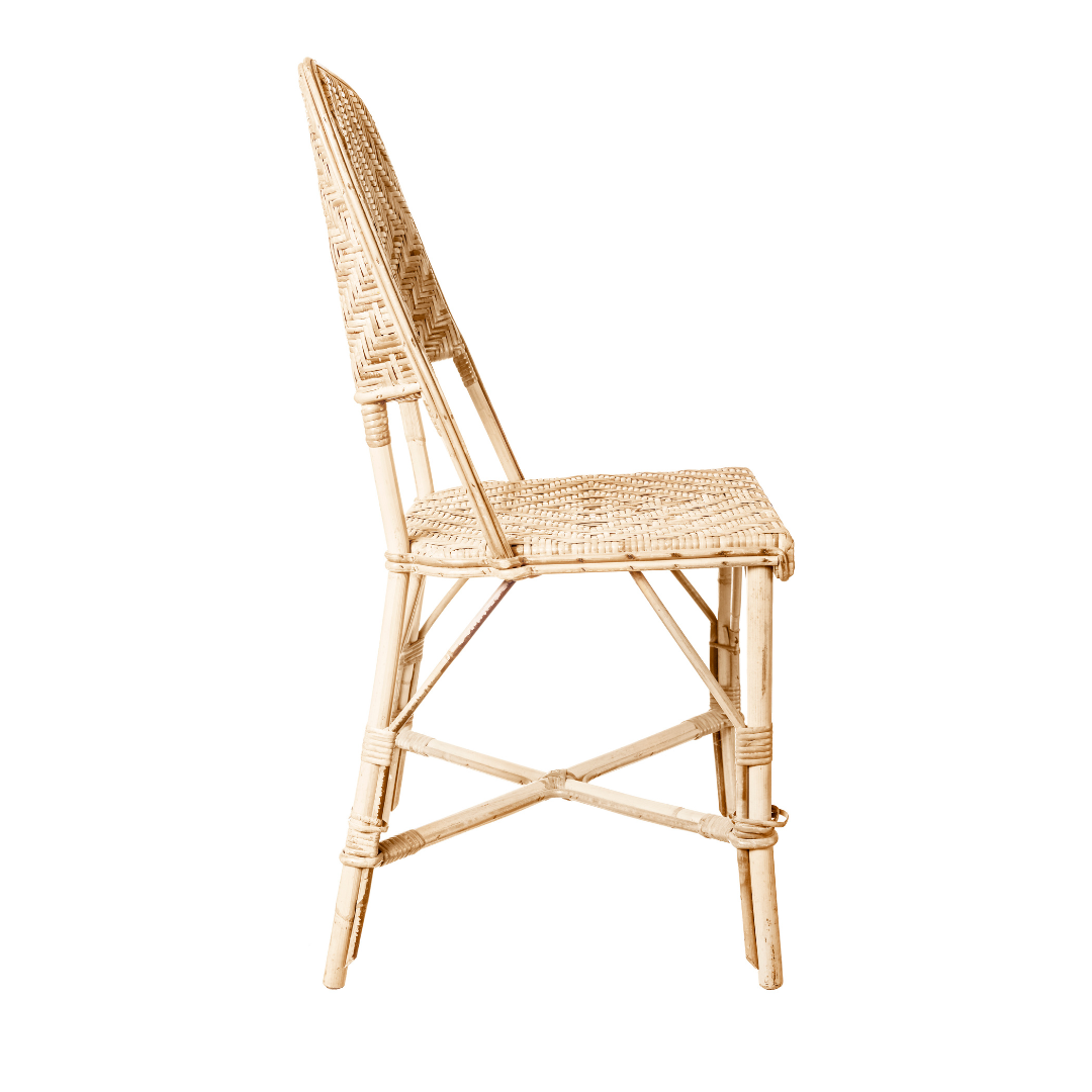 Vista lateral de la Silla de comedor en ratán diseño natural Sara SB, que presenta un respaldo y un asiento tejidos hechos de ratán natural, sostenidos por un elegante marco de madera que incorpora un diseño minimalista.
