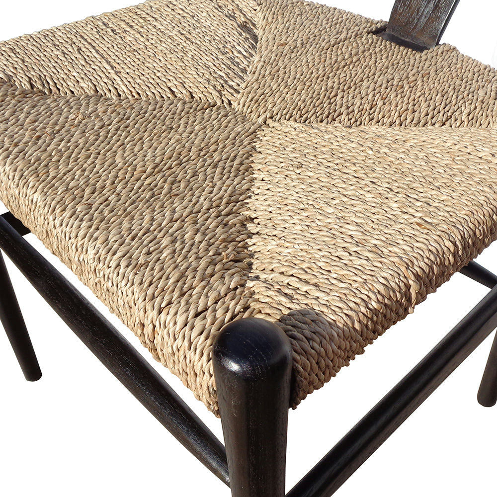 Primer plano de la silla de ratán y madera minimalista U Black, con asiento de paja trenzada y estructura de madera oscura. El elegante diseño muestra una intrincada artesanía y textura.