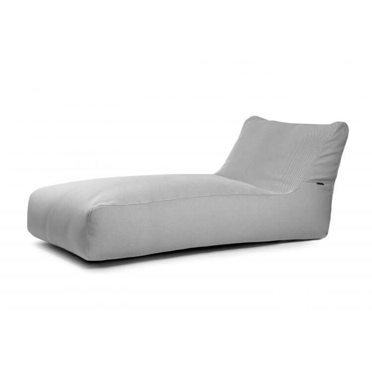 El Bean bag Sunbed 90 Canaria - uso exteriores es un moderno chaise lounge de color gris claro con perfil bajo y respaldo reclinado, ideal para relajarse al aire libre o en espacios contemporáneos sobre un fondo blanco.