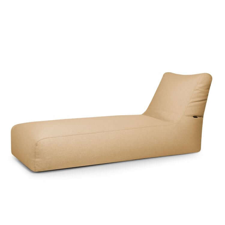 La tumbona Bean Bag Dunes - uso exterior es una moderna tumbona beige de perfil bajo, tapicería afelpada y respaldo en ángulo -una elegante alternativa a las tumbonas tradicionales- que se presenta sobre un fondo blanco liso.