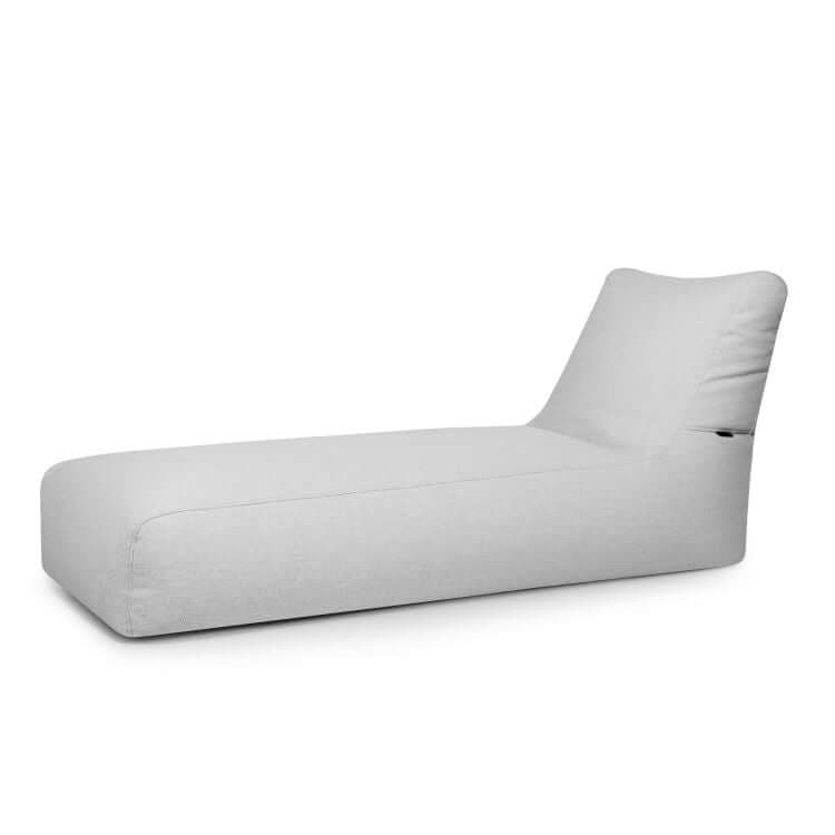 La tumbona Bean Bag Sunbed Dunes - uso exterior es una tumbona moderna y minimalista de color gris claro, con exterior abullonado y perfil bajo, que presenta un respaldo en ángulo, sobre un fondo blanco liso.