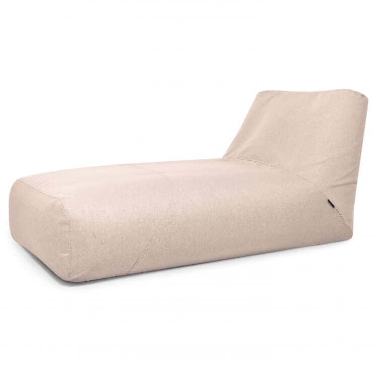 El Bean bag Tube 100 Daybed Riviera es una tumbona de exterior tapizada en tela de color beige claro con un respaldo bajo e inclinado, que ofrece comodidad ergonómica y estilo. Se muestra sobre fondo blanco.