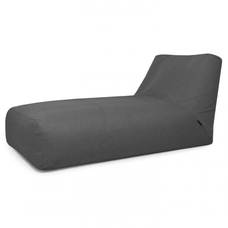 La Bean bag Tube 100 Daybed Riviera es una chaise lounge de color gris oscuro con un diseño bajo y moderno y respaldo inclinado, que ofrece comodidad ergonómica y estilo para uso en exteriores, mostrada sobre un fondo blanco.