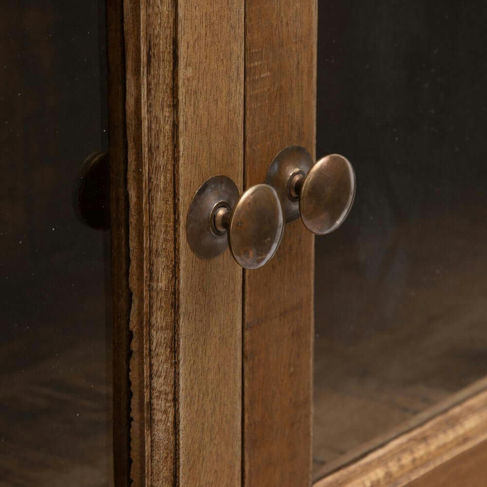 Primer plano de la vitrina de madera y cristal “Natural Display” con puertas de vidrio, que muestra dos pomos redondos de metal.