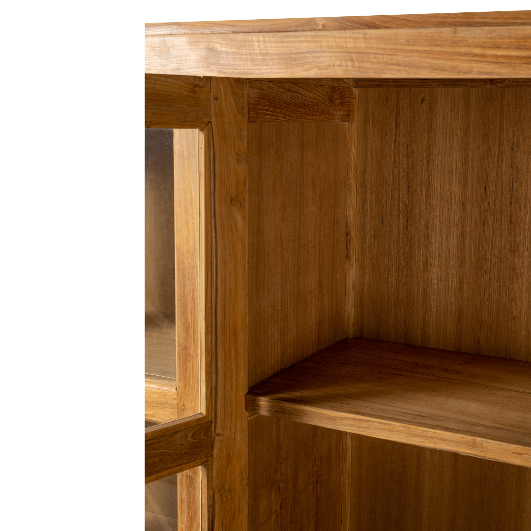 La Vitrina en Madera de Teca Nabila presenta un acabado liso, dos estantes y encarna un diseño funcional, lo que la hace perfecta para la decoración del hogar.