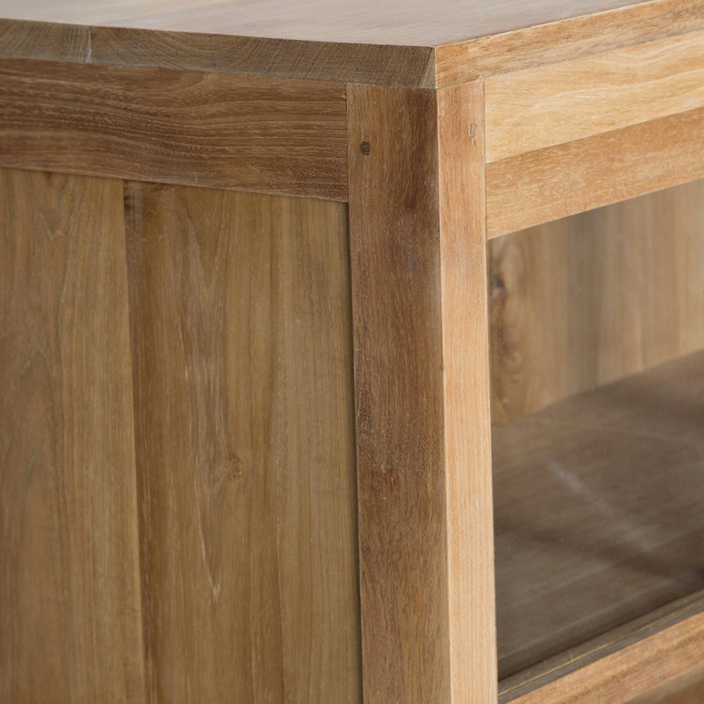 Un primer plano de la Vitrina en Madera de Teca y Cristal Consul en esquina revela la veta y textura de la madera. El elegante diseño con puertas corredizas de cristal realza la funcionalidad y la estética.