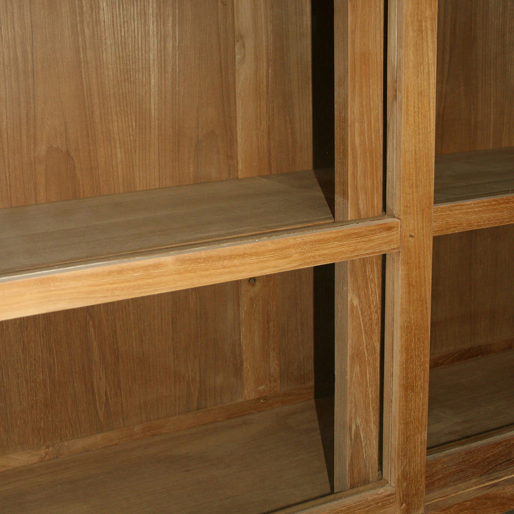 La vitrina en madera de teca y cristal Imam cuenta con estantes de madera abiertos y elegantes puertas de cristal, proporcionando una exhibición impecable para sus tesoros.