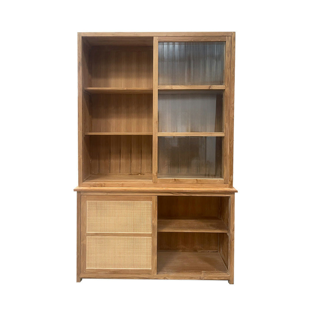 La Vitrina en Madera de Teca y Ratán Imam es un elegante mueble con dos puertas corredizas de vidrio en la parte superior y dos puertas corredizas de ratán en la parte inferior. Combina la elegancia natural con un almacenamiento versátil, ofreciendo estantes abiertos en ambas secciones.
