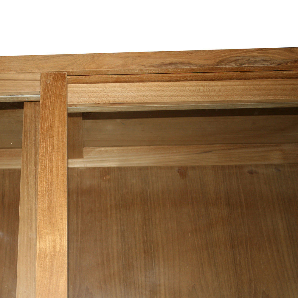 Vista de cerca de la parte inferior de una mesa de madera que muestra vigas de soporte, vetas de madera natural y la elegante Vitrina en Madera de Teca y Ratán Imam.