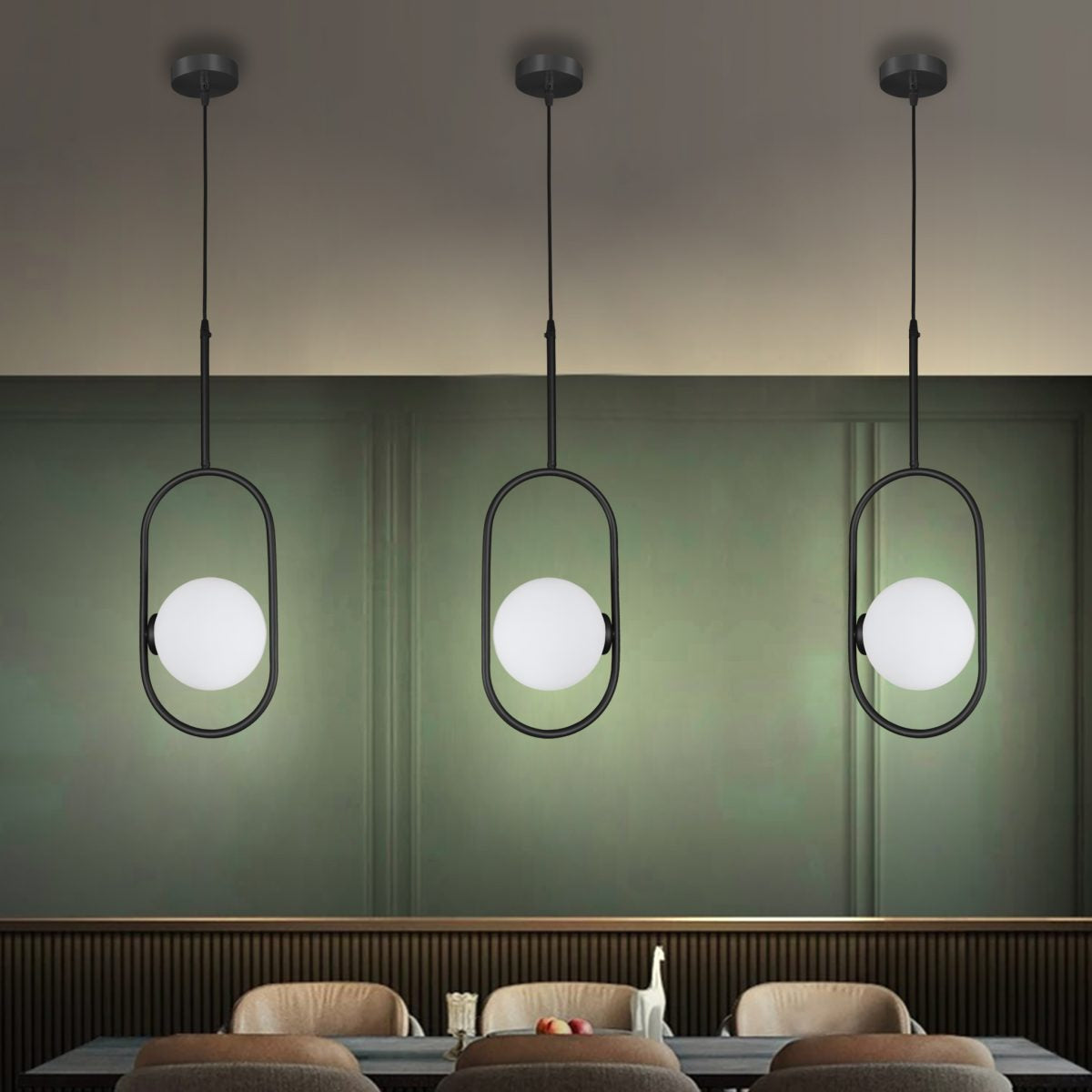 Tres lámparas de techo colgantes modernas 3135-1C cuelgan sobre una mesa de comedor con cuatro sillas marrones contra una pared verde, lo que representa un diseño industrial elegante. Estas lámparas colgantes añaden un toque elegante al ambiente de la habitación.