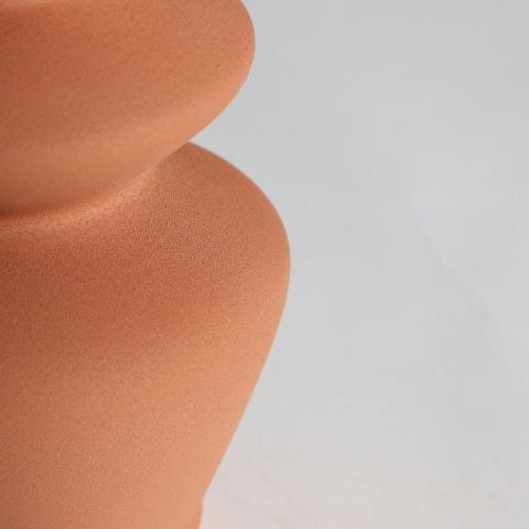 Primer plano de la superficie lisa y curva de la Lámpara de mesa en cerámica Hasna con diseño atemporal, sobre un fondo liso y claro.