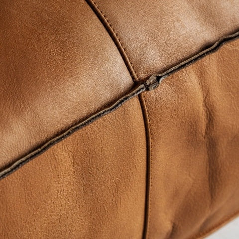 Un primer plano del puff rectangular de cuero marrón Boussac B, resaltando las costuras detalladas y la textura exquisita, que recuerda a un lujoso asiento extra.
