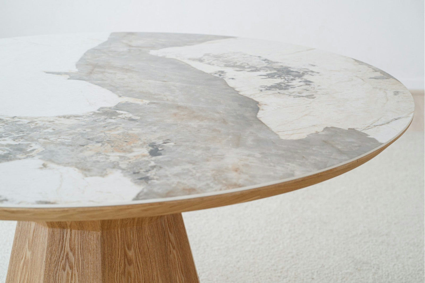 La mesa de comedor redonda en cerámica y fresno Nat Dread es una mesa impresionante con una base de pedestal de madera, que presenta elegantes tonos grises y blancos. Perfecta para cualquier área de comedor, complementa con gracia un piso claro al tiempo que agrega sofisticación que recuerda al arte de la cerámica fina.