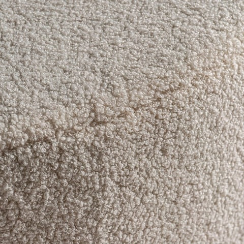 Primer plano del Puff redondo en algodón Bouclé Big BATS, confeccionado en tejido bouclé en color blanco roto con costura diagonal visible, resaltando su diseño moderno.