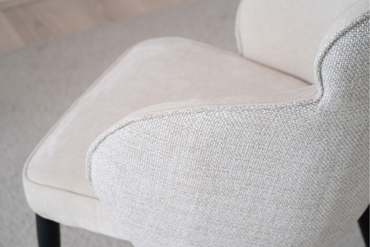 El Pack 2 Sillas de Comedor Tapizadas con Reposabrazos Oslo (Beige) presenta una tela texturizada en color beige claro con patas en color negro, resaltando su diseño moderno. La colección prioriza la comodidad y el estilo, exhibidos con elegancia desde las vistas traseras y laterales.