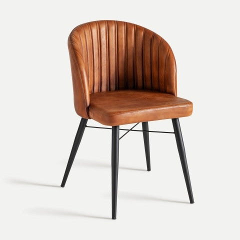 La Silla de comedor en piel y metal Luard es una silla de cuero marrón con respaldo vertical cosido y elegantes patas de metal negro, fusionando a la perfección diseño moderno con estilo y funcionalidad.
