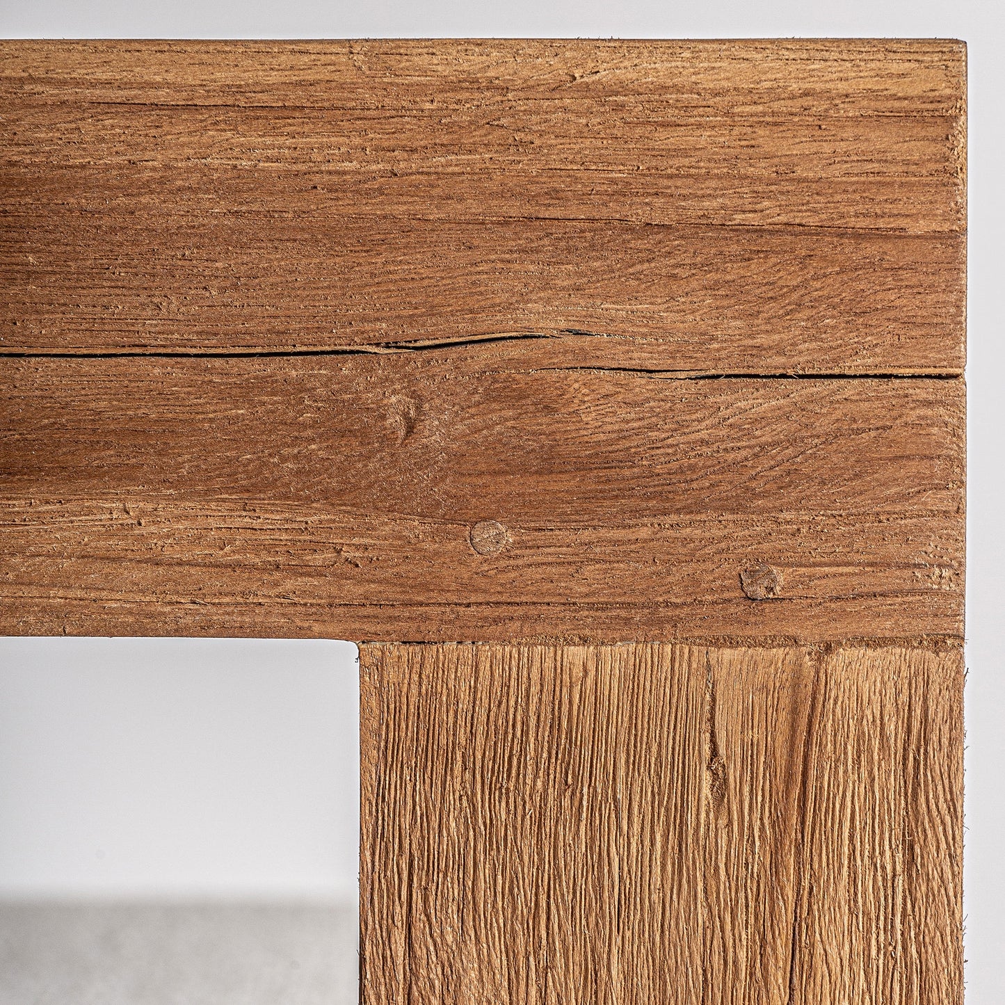 Primer plano de un alféizar de exterior TESTA, fabricado en teca reciclada marrón con tapizado beige resistente al agua, que muestra el veteado natural y los nudos, perfecto para jardines o terrazas sostenibles. 85×85×80 cm.