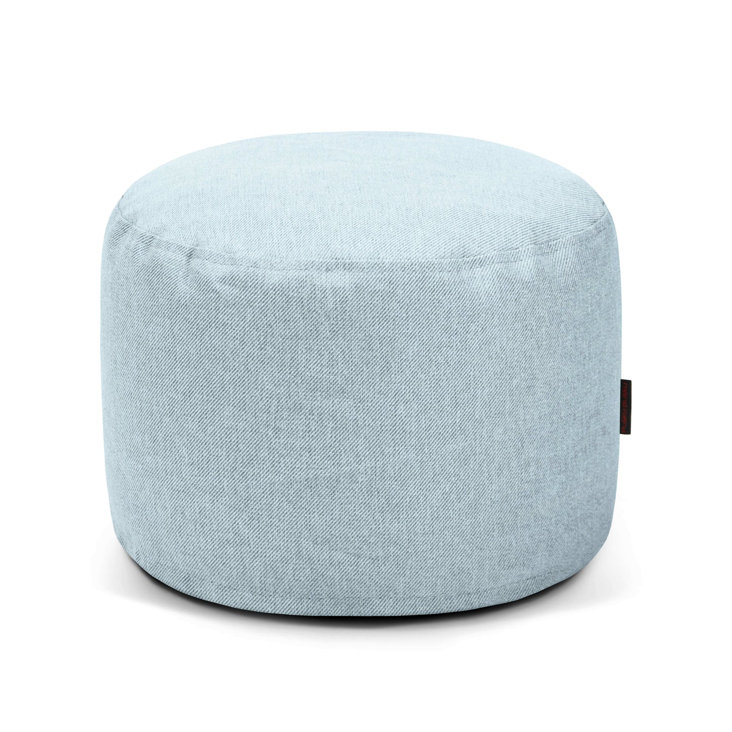 Otomana redonda de tela de color azul claro -Pouf Mini Riviera - uso exterior- con superficie lisa y pequeña etiqueta lateral, mostrada sobre fondo blanco. Perfecto como asiento versátil para espacios modernos de interior o exterior.