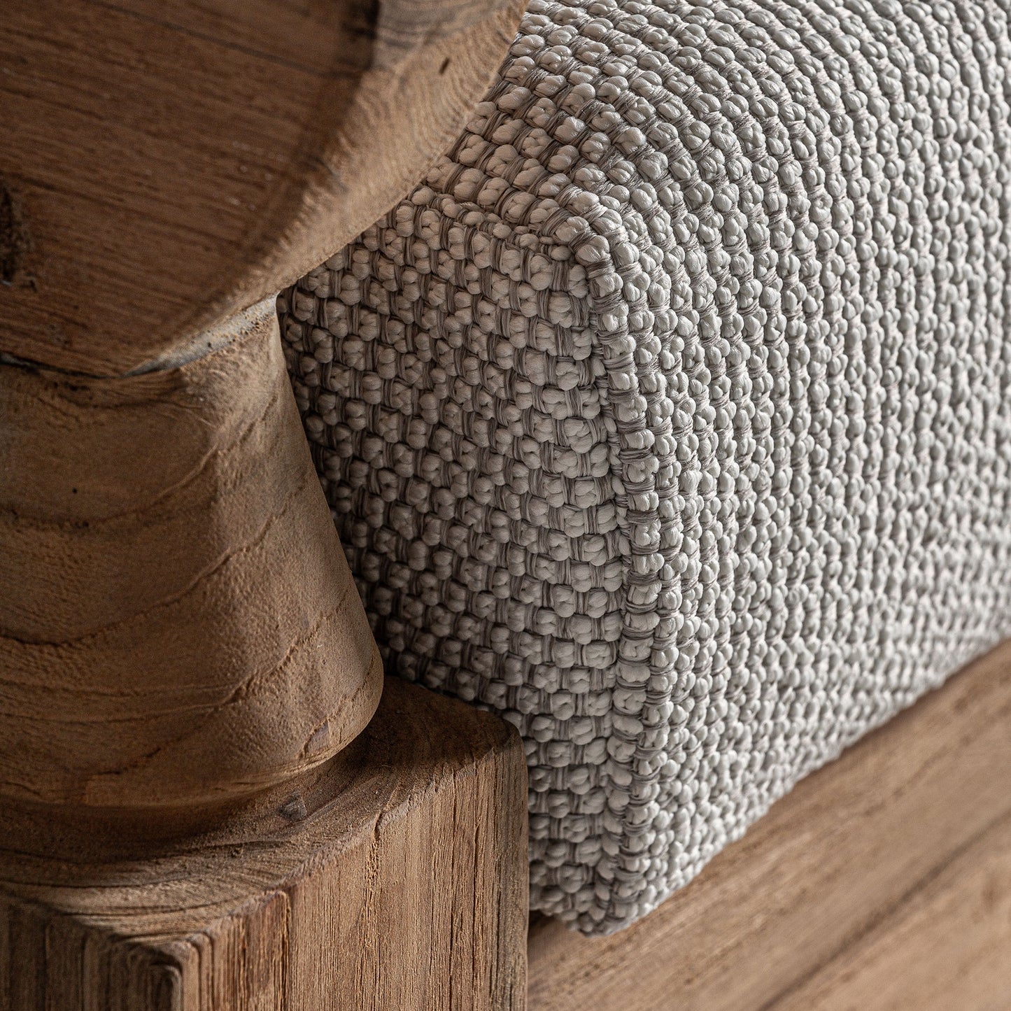 Primer plano de una esquina de somier de madera con tejido gris claro que complementa a la perfección su Sofá de exterior teca reciclada marrón natural y tapizado blanco resistente al agua (250×128×80 cm) JODPHUR para lograr un aspecto armonioso en exteriores.