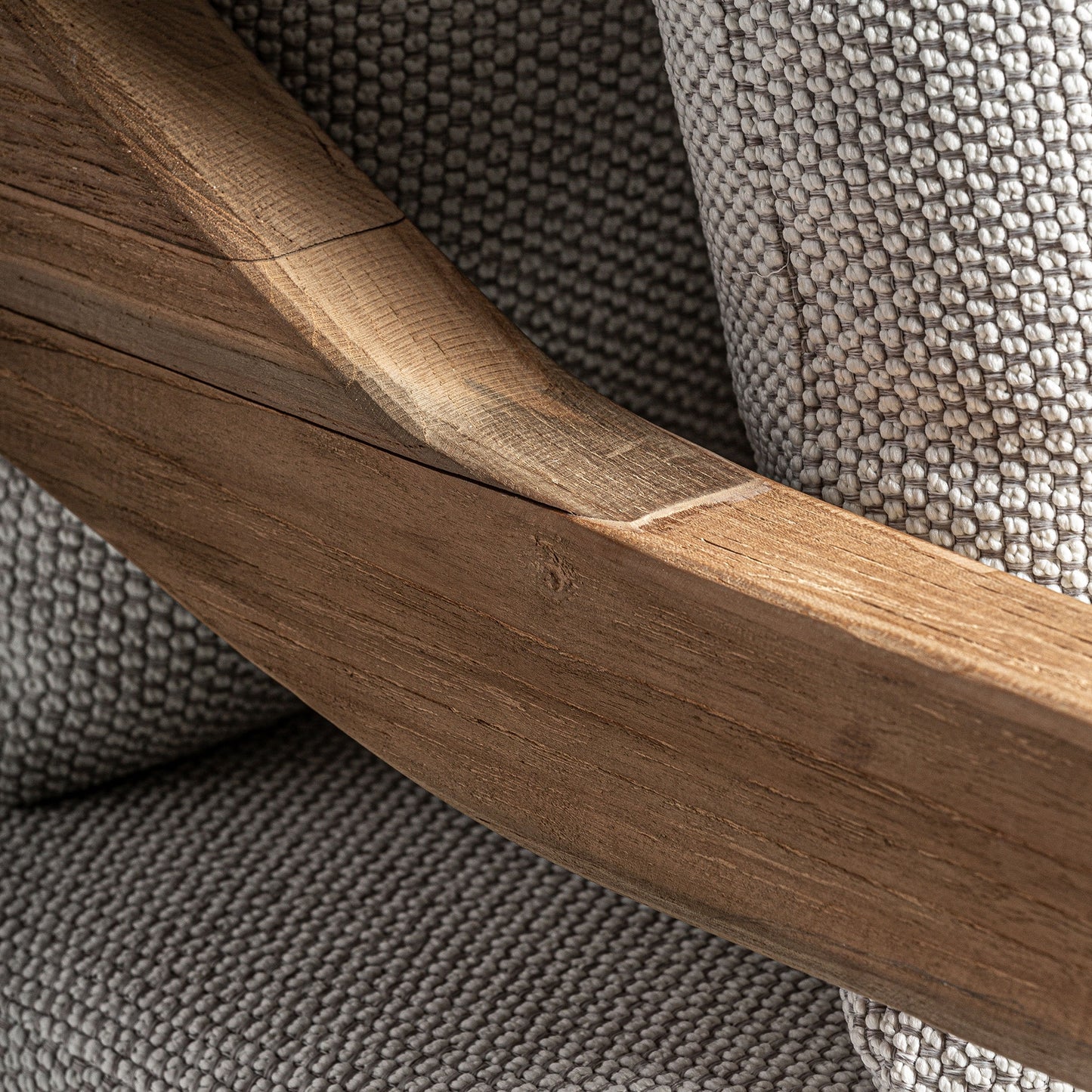 Detalle del cojín beige resistente al agua y del reposabrazos de madera curvada lisa del Sofá modular de exterior JODPHUR, hecho de teca reciclada marrón natural, 130×138×92 cm, ideal para jardín o terraza en estilo colonial moderno.