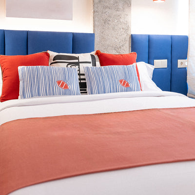Una cama con almohadas a rayas blancas y negras.