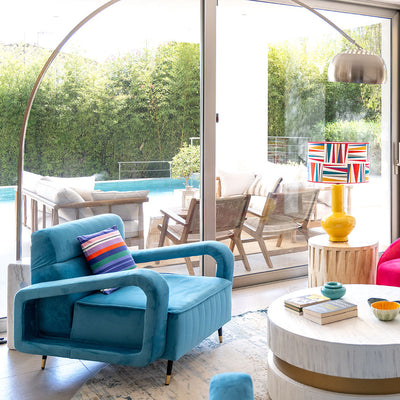 Un salón con sillas azules y una chimenea.