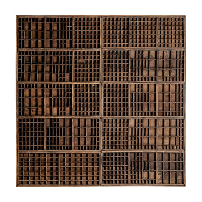 Cesta circular tejida con estampado de espirales en tonos naturales y oscuros.