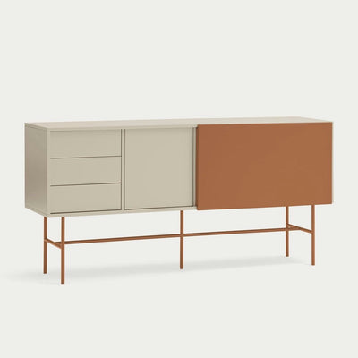 Un aparador moderno con acabado beige, tres cajones, un armario y una gran puerta corredera naranja sobre esbeltas patas naranjas.