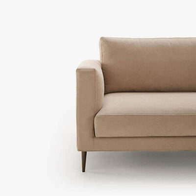 Un sofá beige con patas de madera sobre un fondo blanco.