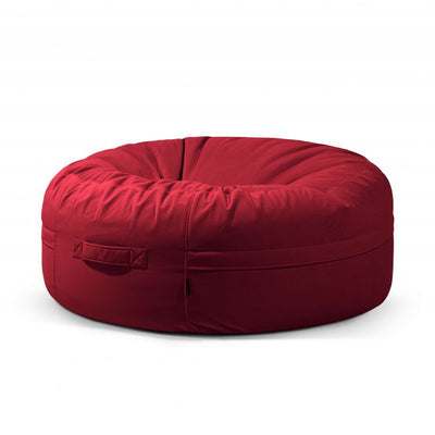 Un sillón puf grande, redondo y de color rojo, con un asa de tela en el lateral, colocado sobre un fondo blanco liso.