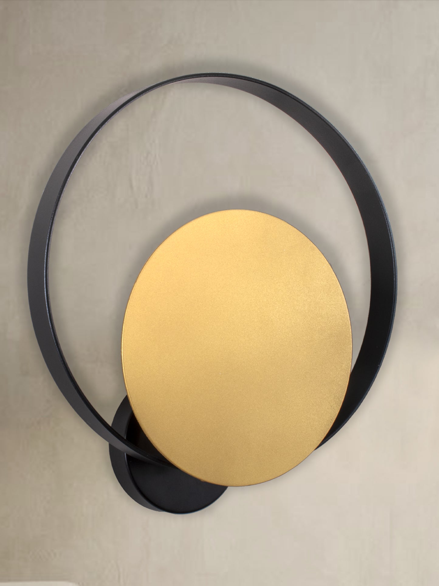 El aplique de pared Echo II presenta un moderno diseño circular negro y dorado sobre un fondo neutro, proporcionando una iluminación suave con su estilo contemporáneo.