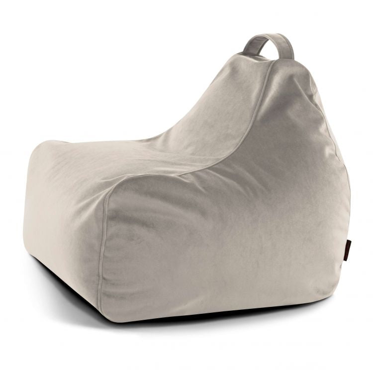 El Bean bag Game Barcelona es una silla infantil de color gris claro, con textura aterciopelada, respaldo y asa superior de tela, ideal como mobiliario infantil. Se presenta sobre un fondo blanco liso.