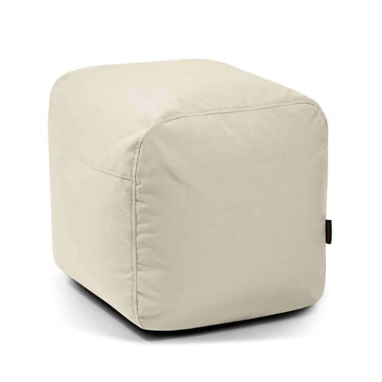 El Pouf Plus 50 Colorin es un puf beige en forma de cubo con un diseño suave y minimalista para exteriores, que ofrece un asiento cómodo y se muestra sobre un fondo blanco liso.