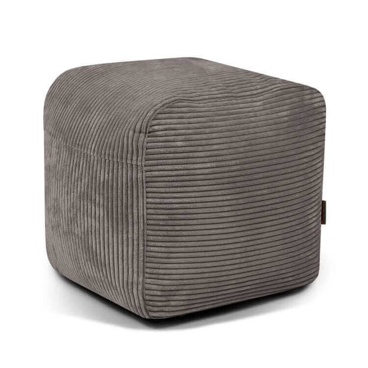 El PLUS 50 WAVES pouf cuadrado de terciopelo acanalado, compacto y ligero (50×50×35 cm), de diseño moderno, ideal para dormitorio o sala de juegos, se muestra en gris sobre un fondo blanco.