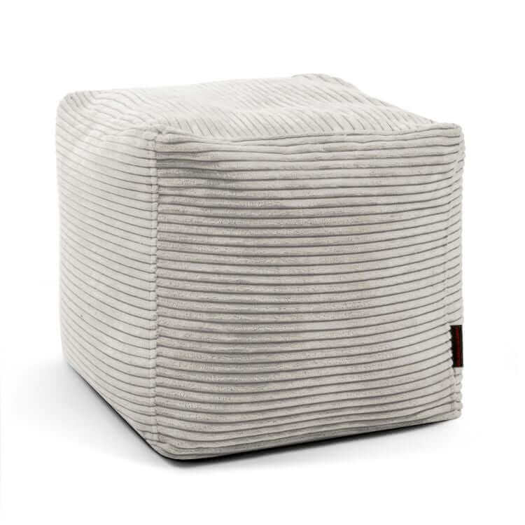 El Puff cuadrado de terciopelo acanalado 45×45×40 cm UP WAVES es un asiento cómodo y reposapiés elegante, ideal para dormitorio o salón, con diseño compacto y textura acanalada, presentado sobre fondo blanco.