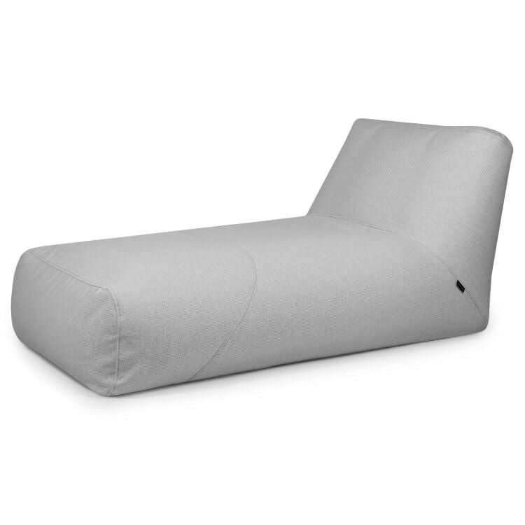 El Bean Bag Tube 100 Daybed Dunes - uso exteriores es un moderno chaise lounge gris claro con un diseño bajo, sin brazos y respaldo en ángulo, perfecto como mueble terraza con estilo para espacios exteriores contemporáneos.