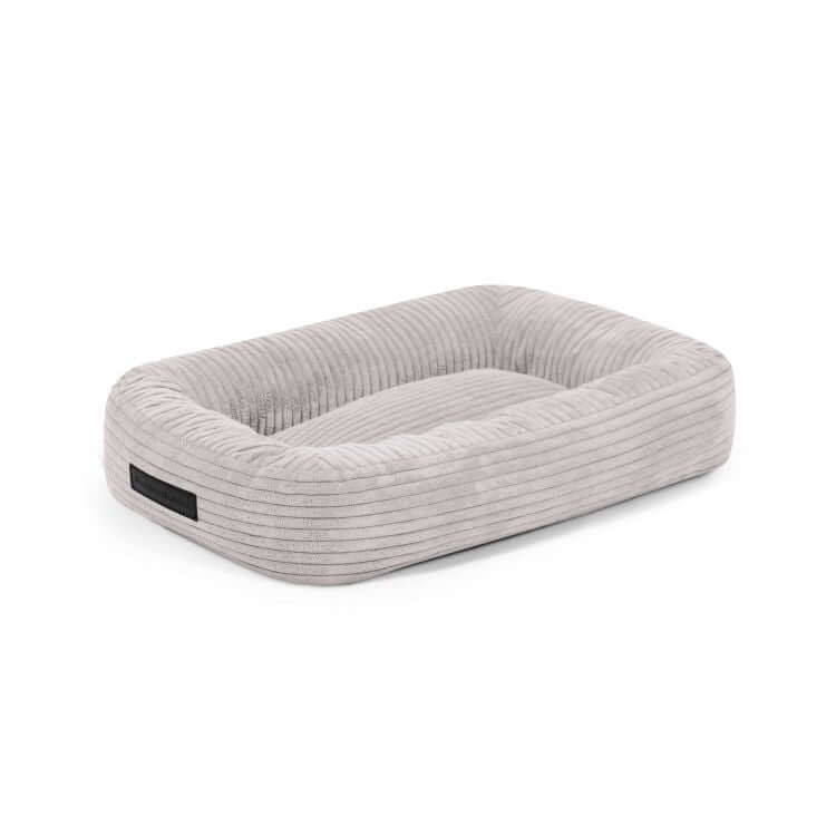 La Cama para perro de terciopelo acanalado 55×45×16 cm DOG BED 55 WAVES es rectangular, gris claro, con bordes elevados e interior suave, ideal como colchón para perros pequeños.