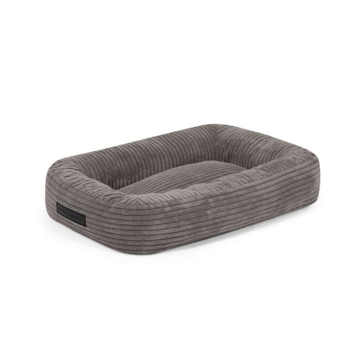 La Cama para perro de terciopelo acanalado 55×45×16 cm - DOG BED 55 WAVES es una cama rectangular de terciopelo gris con laterales elevados y base plana acolchada, ideal como acogedor colchón para perros, mostrada sobre un fondo blanco liso.