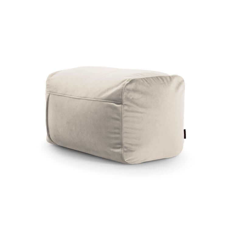 El puf rectangular de terciopelo compacto PLUS 70 BARCELONA (70×60×45 cm), ligero y moderno, en tono beige claro con etiqueta negra lateral, es perfecto como asiento extra para dormitorio o salón.