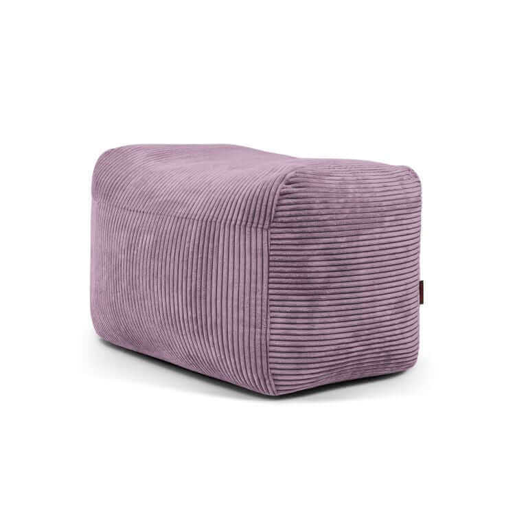 Un compacto y ligero puf rectangular de terciopelo acanalado malva (70×60×45 cm) sobre fondo blanco, ideal como asiento adicional. El moderno estilo PLUS 70 WAVES es ideal para dormitorios y salones.