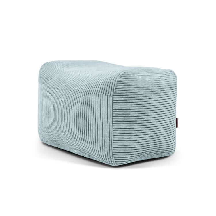 Compacto y ligero puf rectangular de terciopelo acanalado PLUS 70 WAVES (70×60×45 cm) en azul claro, con bordes redondeados-ideal como asiento auxiliar para dormitorio o salón, mostrado sobre un fondo blanco liso.