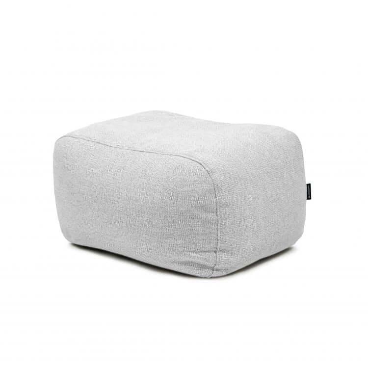 El Bean bag Tube Pouf Dunes, un puf rectangular de tela gris claro con bordes redondeados, se muestra sobre un fondo blanco liso y está diseñado para su uso en exteriores.