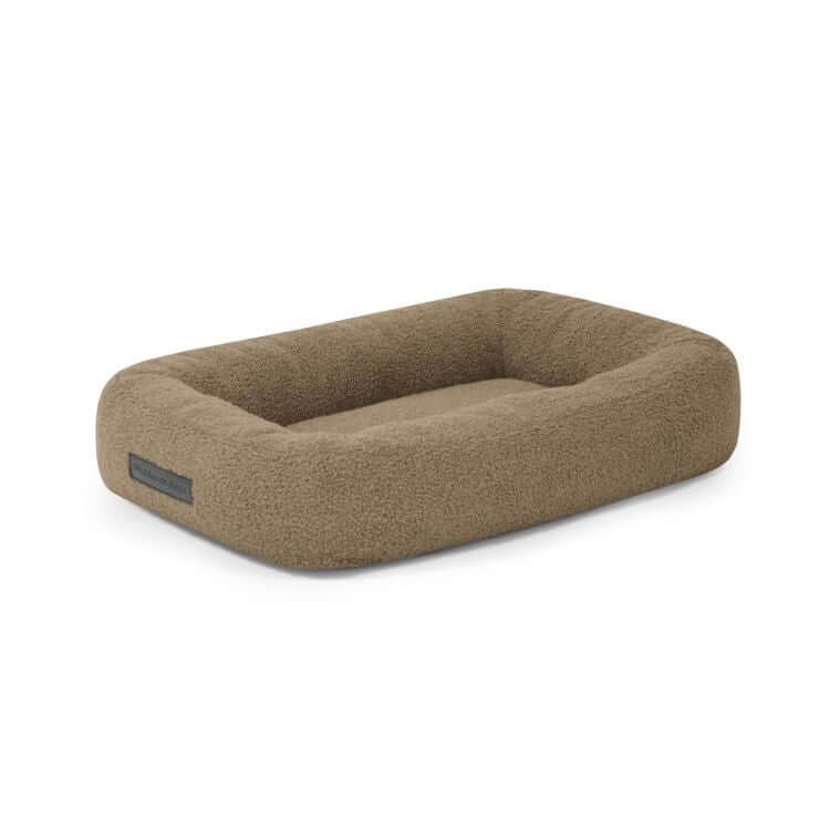 La Cama para perro de tela borreguito 55×45×16 cm - DOG BED 55 TEDDY, rectangular y marrón con laterales elevados y una zona plana para dormir, se muestra sobre un fondo blanco.