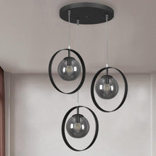  La Lámpara de Techo Colgante Negra Industrial 3222-3C-15-1 cuenta con tres luces colgantes negras con bombillas de vidrio, suspendidas de una lámpara de techo circular y enmarcadas por elegantes círculos negros, que exudan un encanto de diseño industrial.