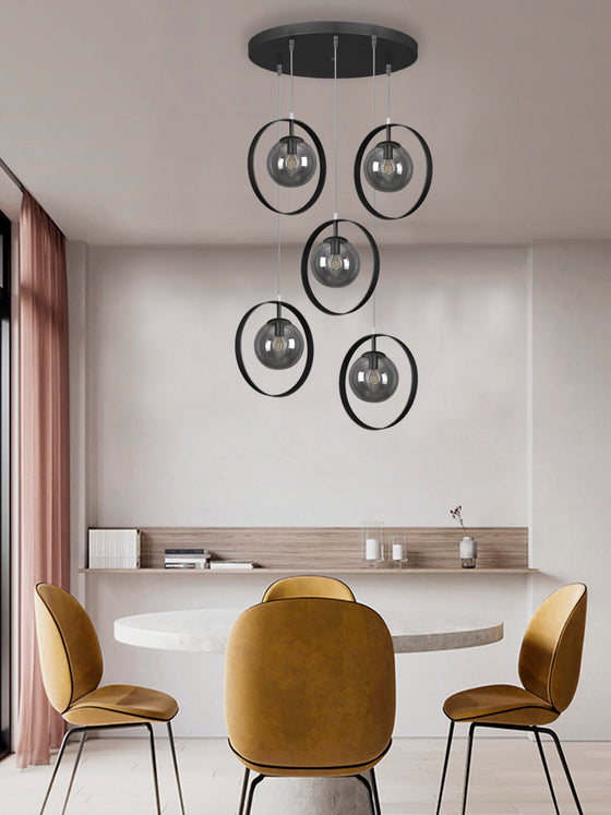 Experimente un diseño de comedor moderno con una mesa circular blanca, cuatro sillas de color amarillo mostaza y la Lámpara de Techo Colgante Círculo Industrial 3222-5C-15-1. Esta lámpara colgante circular negra presenta cinco globos de vidrio en cristal ahumado, que encapsulan a la perfección un diseño moderno.